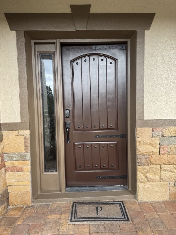 Richly stained wood front door with stone surround